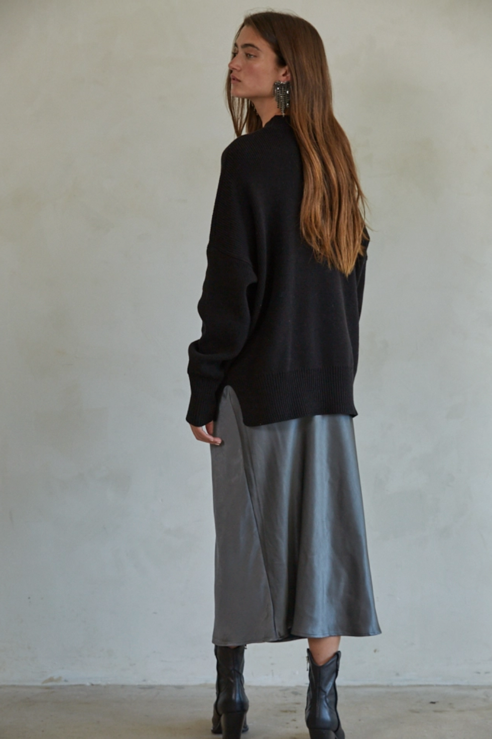 back view model wearing black sweater and satin skirt