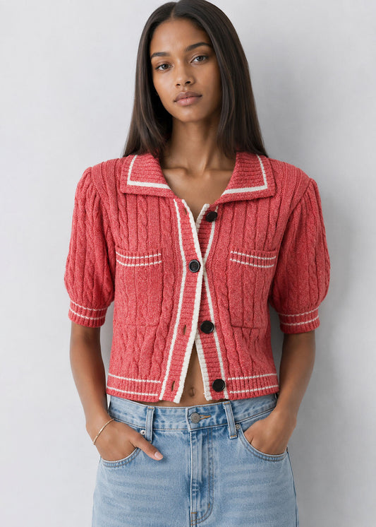 Woman wearing a red textured jacket with white trim against a plain background