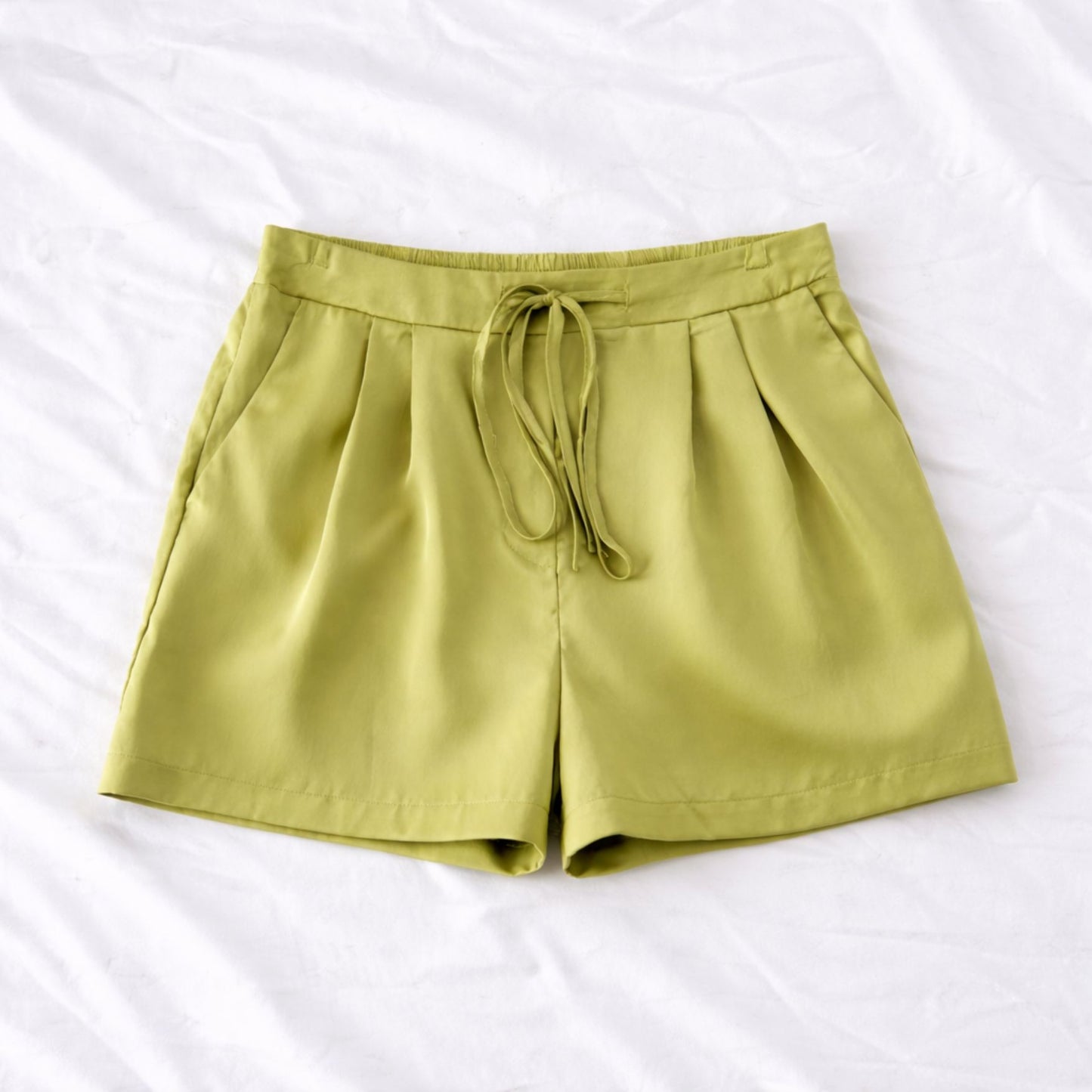 Green shorts with a drawstring on a white background