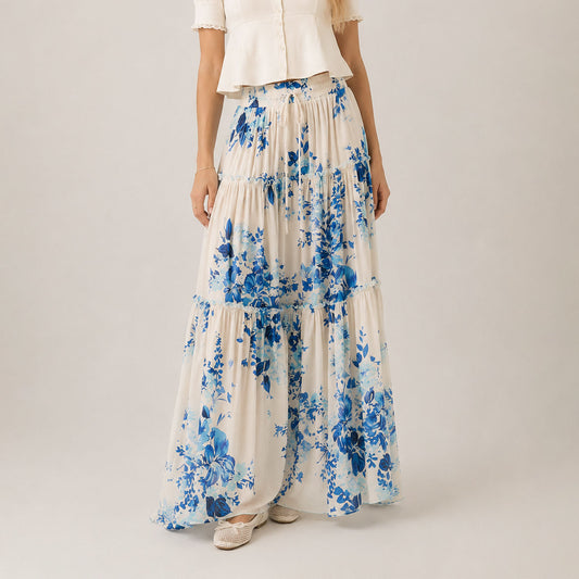 Woman wearing a long floral skirt with a plain background