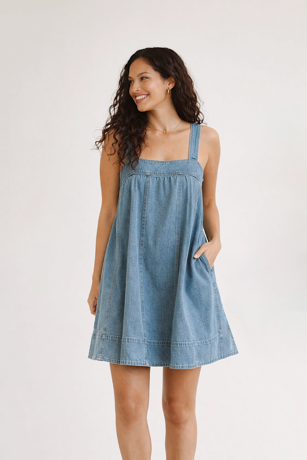 Woman wearing a blue denim dress on a white background
