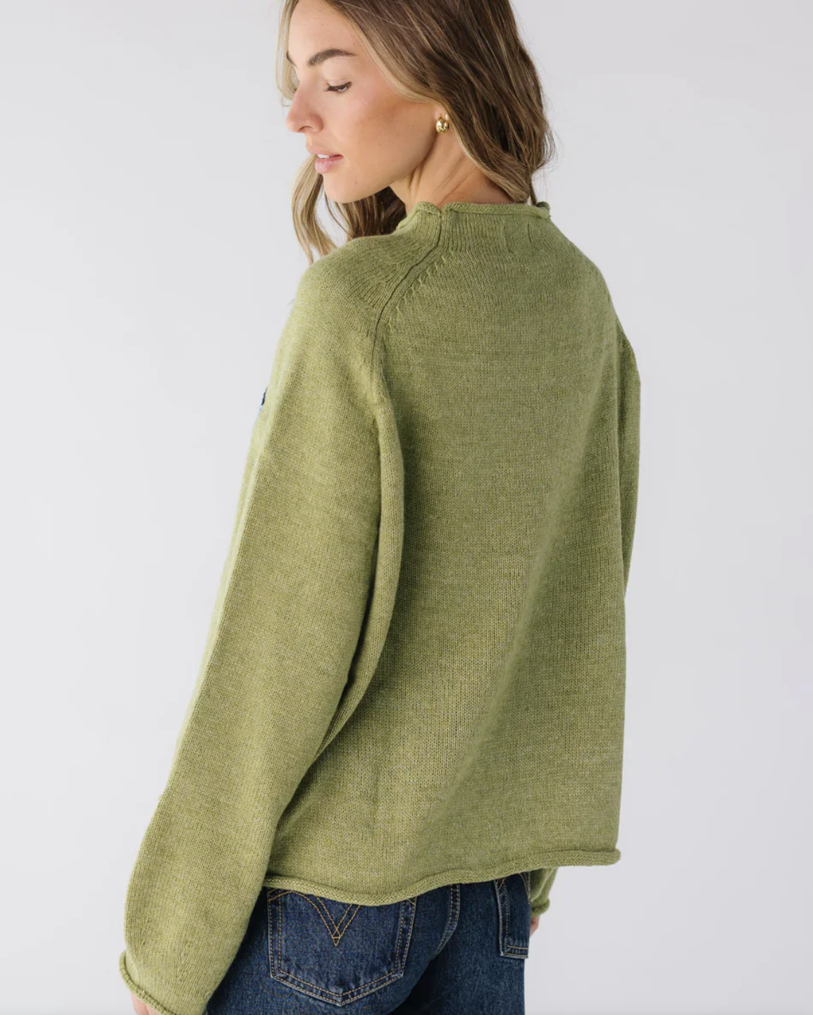 Woman wearing a green sweater against a white background