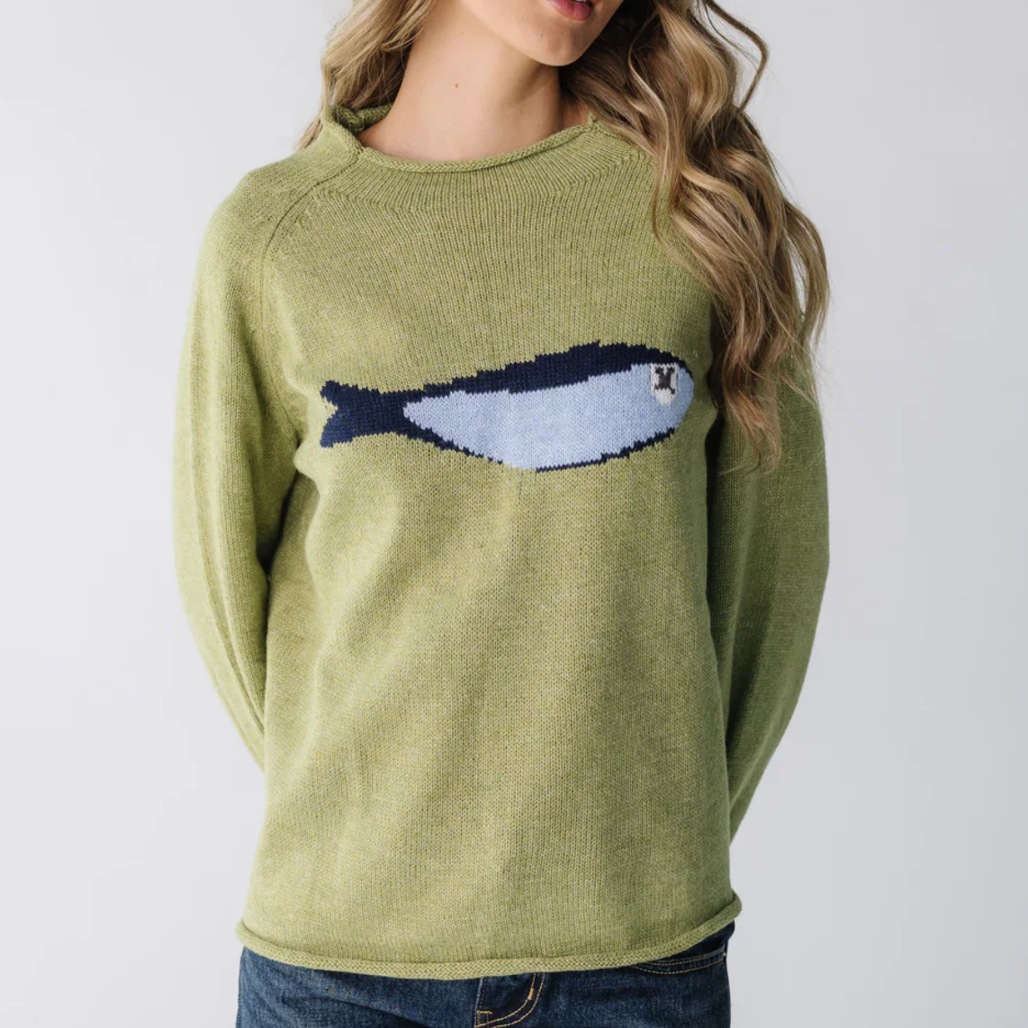Green sweater with fish design worn by a person on a white background