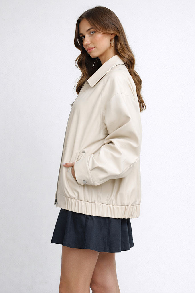 Woman wearing a beige jacket and black skirt on a white background