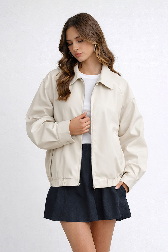 Woman wearing a beige jacket over a white shirt and black skirt on a white background