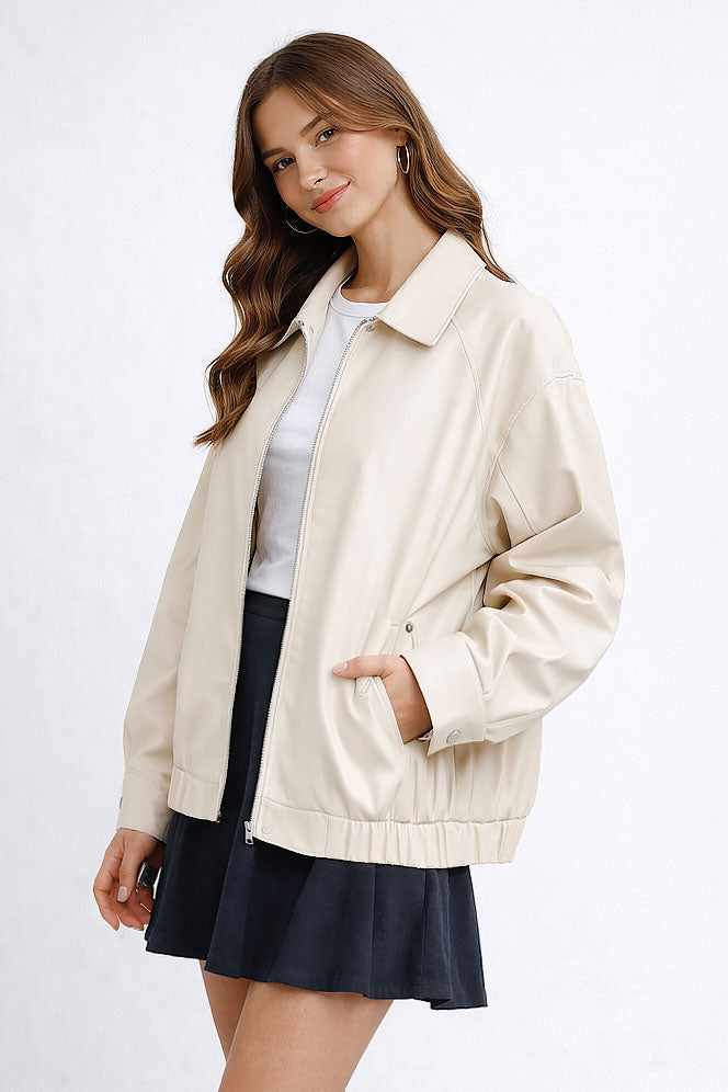 Woman wearing a beige jacket over a white shirt and navy skirt on a white background