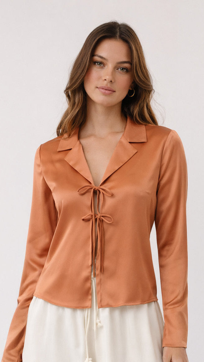 Woman wearing a brown blouse with a white background