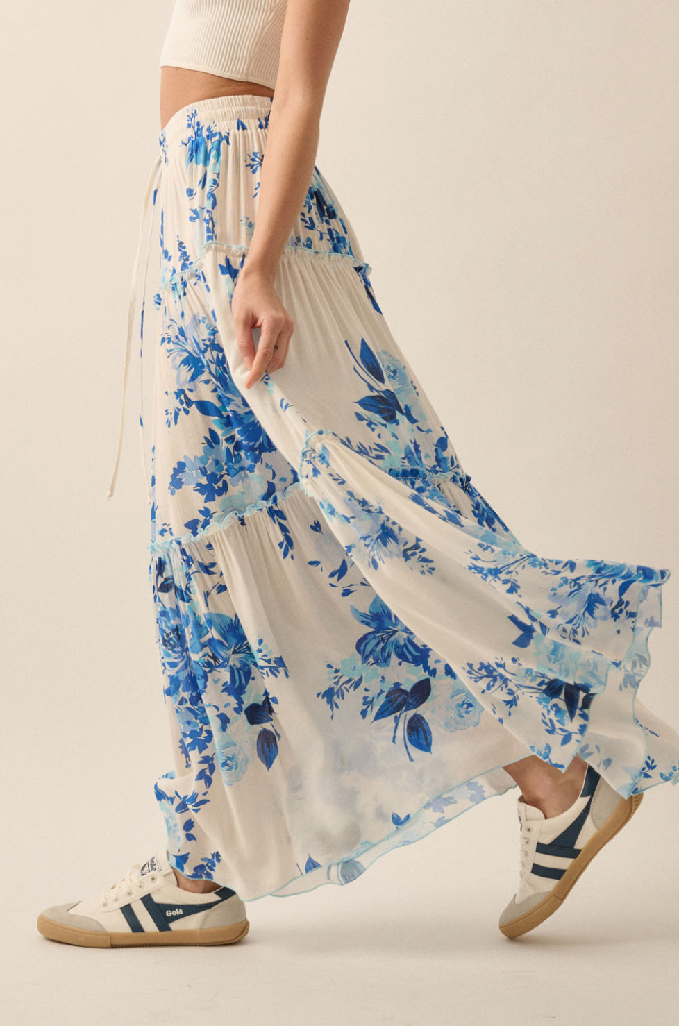 side blue floral skirt with sneakers and plain background