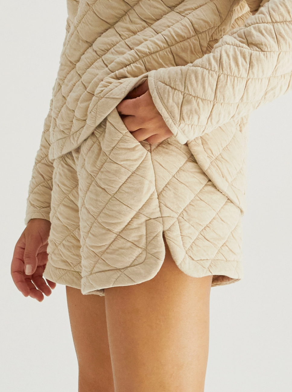 side view model wearing beige quilted shorts with pockets