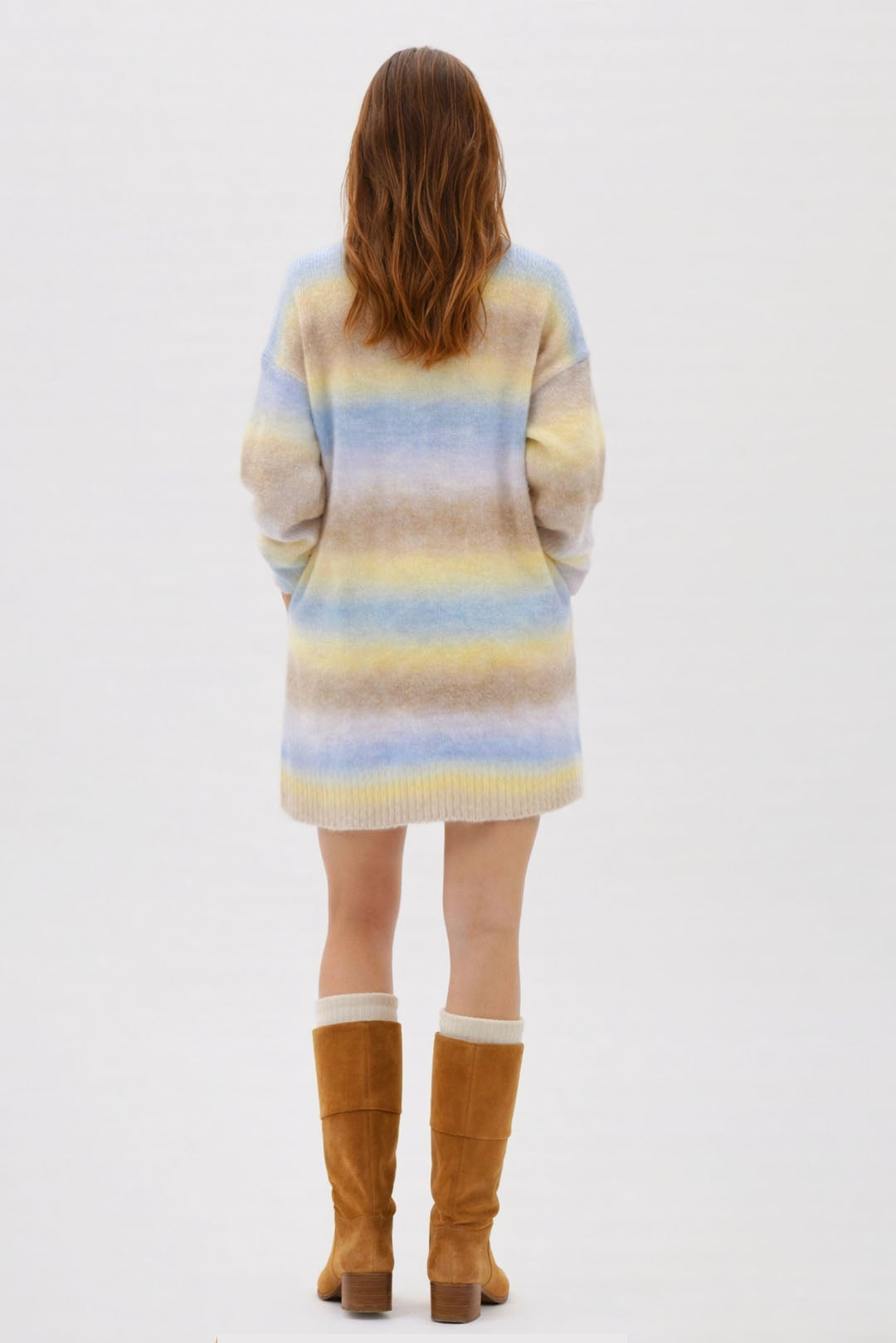 Person wearing a striped sweater and brown boots on a white background