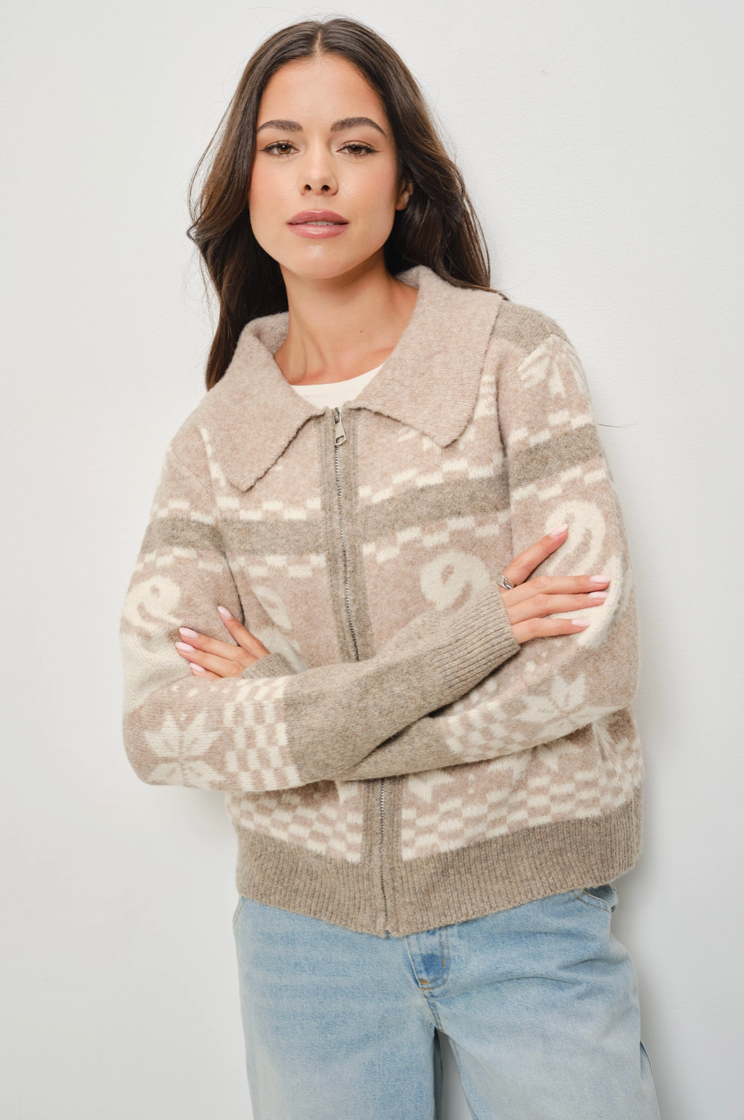 Woman wearing a patterned jacket against a plain background