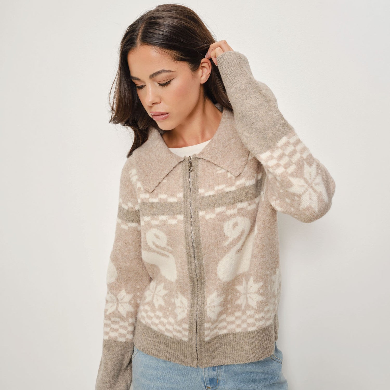 Woman wearing a patterned sweater against a plain background