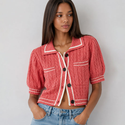 Woman wearing a red textured jacket with white trim against a plain background