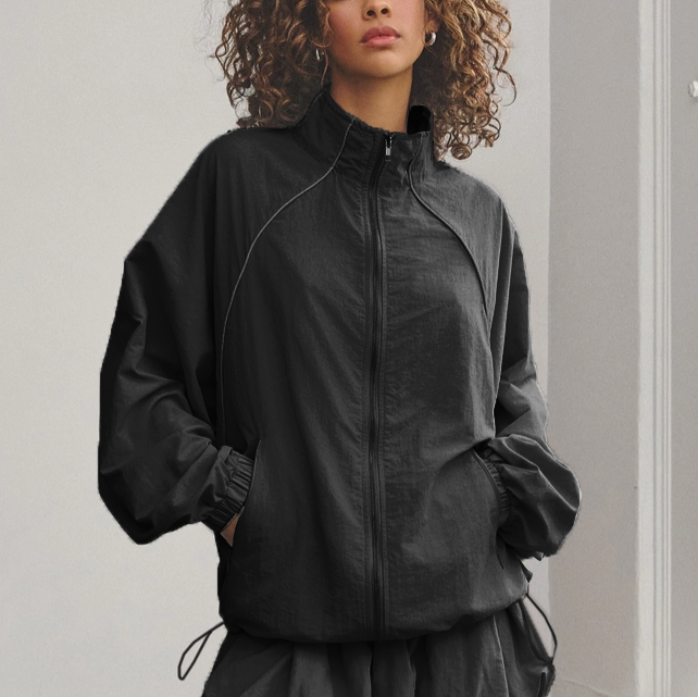 Person wearing a black jacket with a plain background