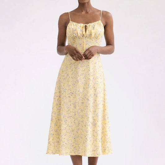 Woman wearing a yellow floral dress on a white background