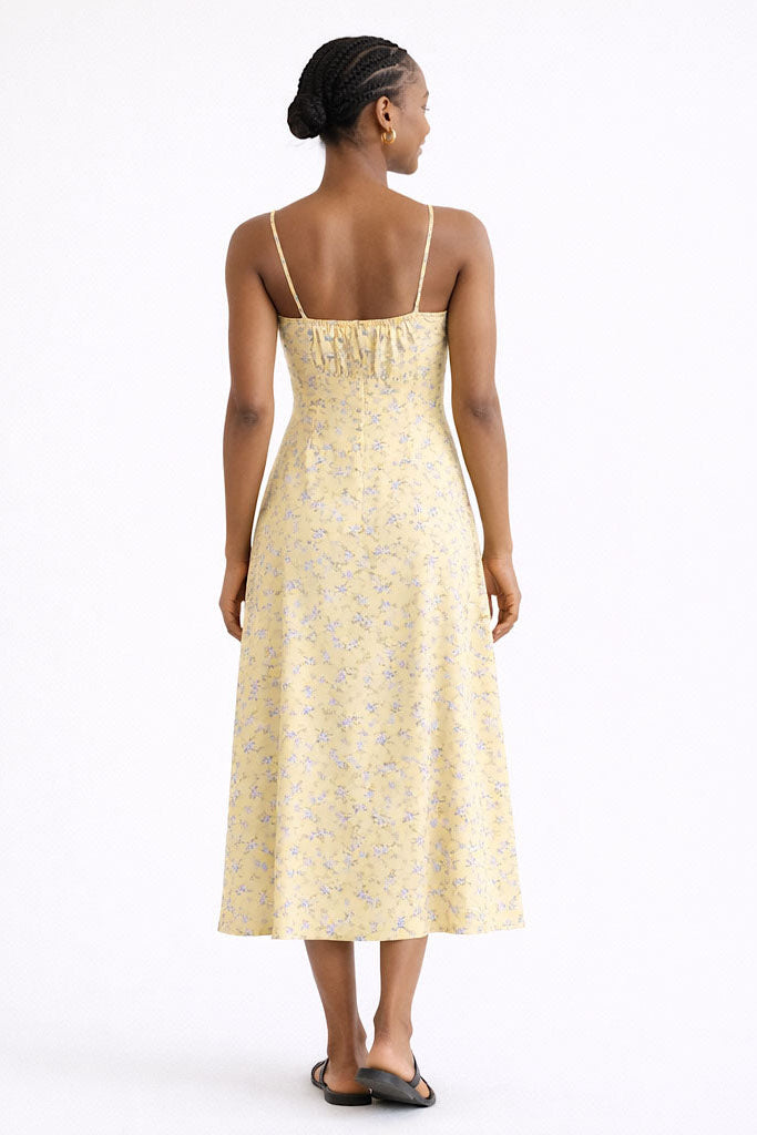 Woman wearing a yellow floral dress on a white background