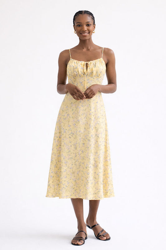 Woman wearing a yellow floral dress on a white background
